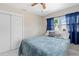 Well-lit bedroom includes a ceiling fan, closet, and a window with blue curtains at 507 Raymond Ave, Frostproof, FL 33843