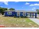 Charming blue house with well-maintained front yard and covered parking area at 507 Raymond Ave, Frostproof, FL 33843