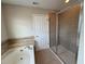 Bathroom featuring a soaking tub and a separate glass-enclosed shower at 5213 Northlawn Way, Orlando, FL 32811