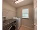 Functional laundry room with appliances, shelving, and a window for natural light at 5213 Northlawn Way, Orlando, FL 32811