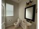 Featuring a pedestal sink and framed mirror, this half-bath exudes simple charm at 5213 Northlawn Way, Orlando, FL 32811