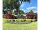 Kingswood Manor entrance sign with well-manicured landscaping, shrubs, and lush trees under a blue sky at 5606 Eggleston Ave, Orlando, FL 32810
