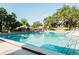 Community pool surrounded by lush greenery and a wrought iron fence at 604 Chestnut Oak Cir # 106, Altamonte Springs, FL 32701