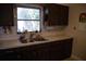 Well-lit kitchen area showcasing a stainless steel sink and dark wood cabinetry at 704 Beverly Ave, Altamonte Springs, FL 32701