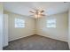 Spacious bedroom with carpeted floors, a ceiling fan, neutral walls, and two windows for natural light at 72 Campus View Dr, Orlando, FL 32810