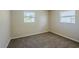 This spacious bedroom features two windows for natural light, neutral walls, and cozy carpeting at 72 Campus View Dr, Orlando, FL 32810