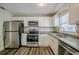 This kitchen offers stainless appliances, granite counters, and bright white cabinets at 72 Campus View Dr, Orlando, FL 32810