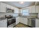 Updated kitchen features stainless appliances, granite counters, and white cabinets at 72 Campus View Dr, Orlando, FL 32810