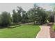 Landscaped backyard with brick pathway, retaining wall, and lush greenery, offering serene outdoor space at 753 Grey Heron Pl, Chuluota, FL 32766