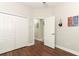 Neutral bedroom with wood-look floors, white doors and trim, and ample closet space at 753 Grey Heron Pl, Chuluota, FL 32766
