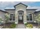 Close-up of home's entrance showcasing stone accents, detailed windows, and a well-maintained walkway at 753 Grey Heron Pl, Chuluota, FL 32766