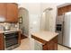 Kitchen island with countertop, wine refrigerator, and stainless steel refrigerator at 753 Grey Heron Pl, Chuluota, FL 32766