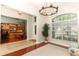 Open living area featuring tile and wood flooring, an elegant chandelier, and views into the office at 753 Grey Heron Pl, Chuluota, FL 32766