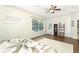 Bright main bedroom featuring hard wood floors, ceiling fan, and a window overlooking the screened-in pool at 753 Grey Heron Pl, Chuluota, FL 32766