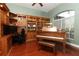 Dedicated office with custom built-in shelving, desk area, and a vintage grand piano at 753 Grey Heron Pl, Chuluota, FL 32766