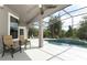 Screened-in patio with tiled deck, chairs, ceiling fan, and pool with waterfall feature at 753 Grey Heron Pl, Chuluota, FL 32766