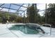 Inviting in-ground pool with waterfall feature surrounded by a screened lanai with lush landscaping at 753 Grey Heron Pl, Chuluota, FL 32766