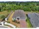 Stunning aerial view of a well-maintained single-Gathering home with brick driveway and lush landscaping, backing up to a greenbelt at 7651 Five Oaks Dr, Harmony, FL 34773