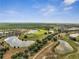 Panoramic aerial view of a community golf course surrounded by lush landscaping and beautiful lakes with homes in the distance at 7651 Five Oaks Dr, Harmony, FL 34773