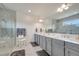 Bright bathroom features a walk-in shower with seat, double vanity and grey accents at 7651 Five Oaks Dr, Harmony, FL 34773
