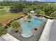 Aerial view of a large community pool with palm trees, lounge chairs and a gazebo surrounded by manicured landscaping at 7651 Five Oaks Dr, Harmony, FL 34773