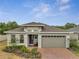 This single-Gathering home boasts a well-manicured lawn, brick driveway, and modern architectural elements at 7651 Five Oaks Dr, Harmony, FL 34773