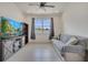Cozy living room with a ceiling fan, large window, and comfortable seating at 7651 Five Oaks Dr, Harmony, FL 34773