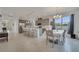 Open-concept living space with kitchen island, dining area, and bar seating with modern tile flooring at 7651 Five Oaks Dr, Harmony, FL 34773