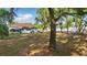 Large backyard with lush landscaping, mature trees, and a screened in pool creating a serene outdoor oasis at 841 Oaks Shores Rd, Leesburg, FL 34748