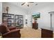 Inviting bedroom with leather chair, bookshelves displaying toy cars, and a TV above a decorative cabinet at 841 Oaks Shores Rd, Leesburg, FL 34748