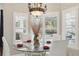 Bright dining area with shuttered windows, modern chandelier and views of pool at 841 Oaks Shores Rd, Leesburg, FL 34748