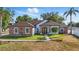 Charming home with a stone facade, lush landscaping, and inviting entry, offering great curb appeal at 841 Oaks Shores Rd, Leesburg, FL 34748