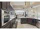 This kitchen includes stainless appliances, pendant lighting, granite countertops, and navy blue cabinets at 841 Oaks Shores Rd, Leesburg, FL 34748