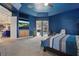 Large primary bedroom with blue ceiling and wall, view to outdoor space, and sitting area at 841 Oaks Shores Rd, Leesburg, FL 34748