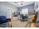 Home office featuring a comfortable chair, glass desk, built-in shelving, and light blue walls at 841 Oaks Shores Rd, Leesburg, FL 34748