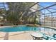 Screened pool with hot tub, landscaping, and table with seating for enjoying a backyard oasis at 841 Oaks Shores Rd, Leesburg, FL 34748
