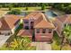 Aerial shot of a two-story home, with solar panels, overlooking a peaceful lake at 9020 Breezy Meadow Way, Orlando, FL 32829