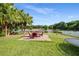 Inviting backyard with patio set, palm trees, trampoline, and lake views at 9020 Breezy Meadow Way, Orlando, FL 32829