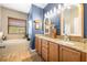 Well-lit bathroom with a double sink vanity, granite countertop, a soaking tub, and nautical themed decor at 9020 Breezy Meadow Way, Orlando, FL 32829