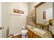 Well lit half bath with tile floors and a granite vanity top at 9020 Breezy Meadow Way, Orlando, FL 32829