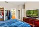 Open bedroom view to a walk-in closet and bathroom, complemented by a large television on a wooden dresser at 9020 Breezy Meadow Way, Orlando, FL 32829
