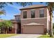 Front exterior view of a two-story home with well-manicured landscaping and a two-car garage at 9020 Breezy Meadow Way, Orlando, FL 32829