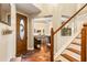 Foyer features a wooden door with decorative glass, tile flooring, staircase, and view of dining area at 9020 Breezy Meadow Way, Orlando, FL 32829