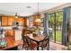 Eat-in kitchen with wooden cabinets, island, and sliding doors to backyard with grill and hammock at 9020 Breezy Meadow Way, Orlando, FL 32829