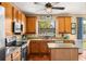 Well-lit kitchen with wooden cabinets, granite countertops, stainless appliances, and tile flooring at 9020 Breezy Meadow Way, Orlando, FL 32829