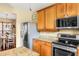 Kitchen with stainless appliances, granite countertops, wooden cabinets, open to dining area at 9020 Breezy Meadow Way, Orlando, FL 32829