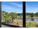 Balcony view showcases a serene lake with seating, palm trees, and landscaping at 9020 Breezy Meadow Way, Orlando, FL 32829