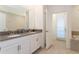 Bathroom with a double vanity, neutral color scheme, and access to an outdoor area at 9332 Sommerset Hills Dr, Davenport, FL 33896