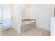 Inviting soaking tub area with tile surround and natural light from the door at 9332 Sommerset Hills Dr, Davenport, FL 33896