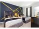 Bedroom featuring two beds with decorative pillows and bold gold and black accent wall at 9332 Sommerset Hills Dr, Davenport, FL 33896